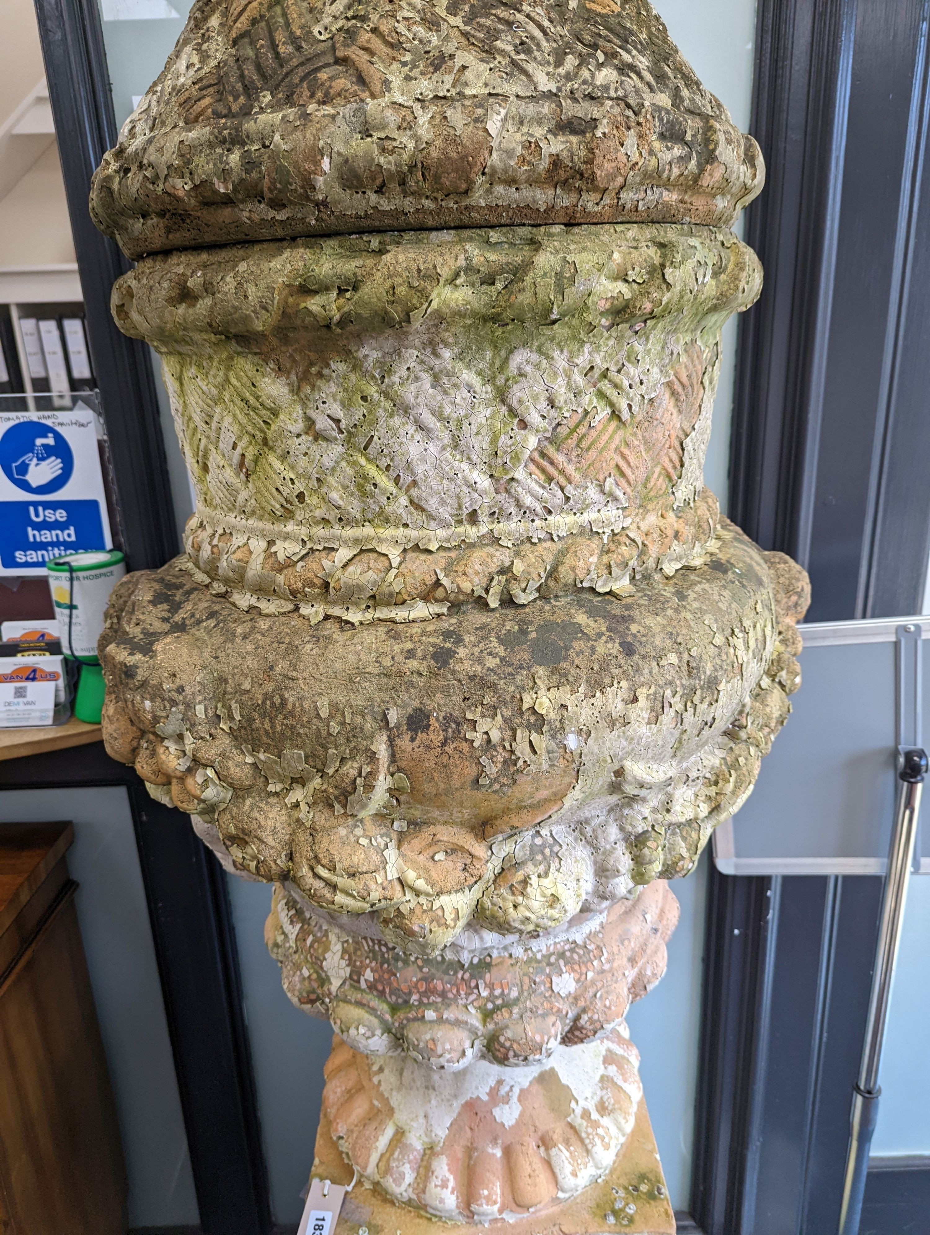 A large weathered Victorian painted terracotta lidded urn on plinth base, diameter 64cm, height 200cm